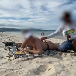 Ksada na praia com desconhecidos passando o protetor